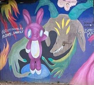 Street art of scared looking bunny being held by a lizard of some sort with horns